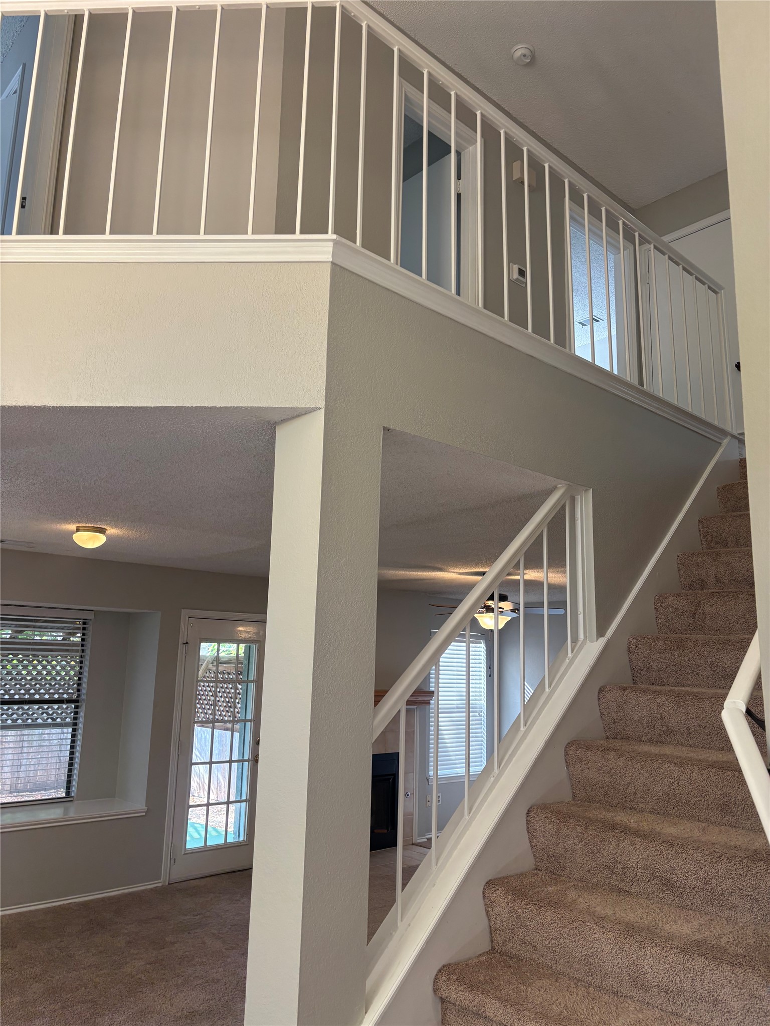 12915 Modena Trail Austin, TX 78729 - Photo 10 of 19 An open multi-level layout connects the main living spaces with carpeted stairs and protective railings.