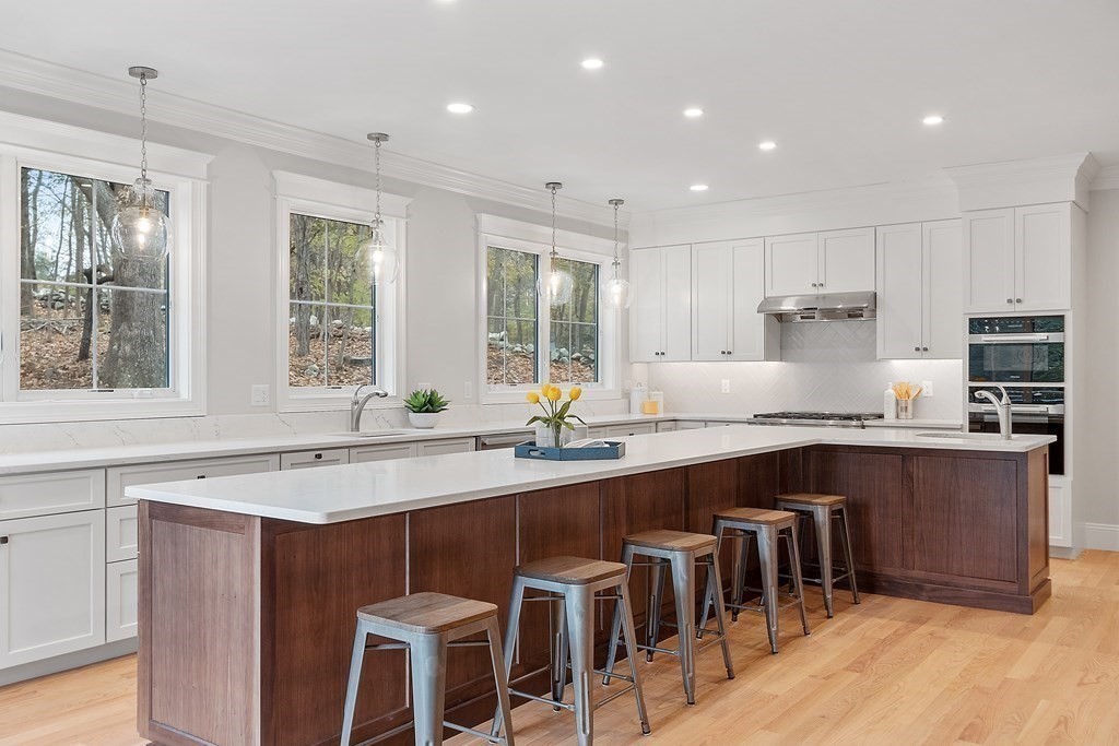 4 Mill Brook Road Lexington, MA 02420 - Photo 14 of 42 a kitchen with stainless steel appliances granite countertop a table chairs sink refrigerator and microwave