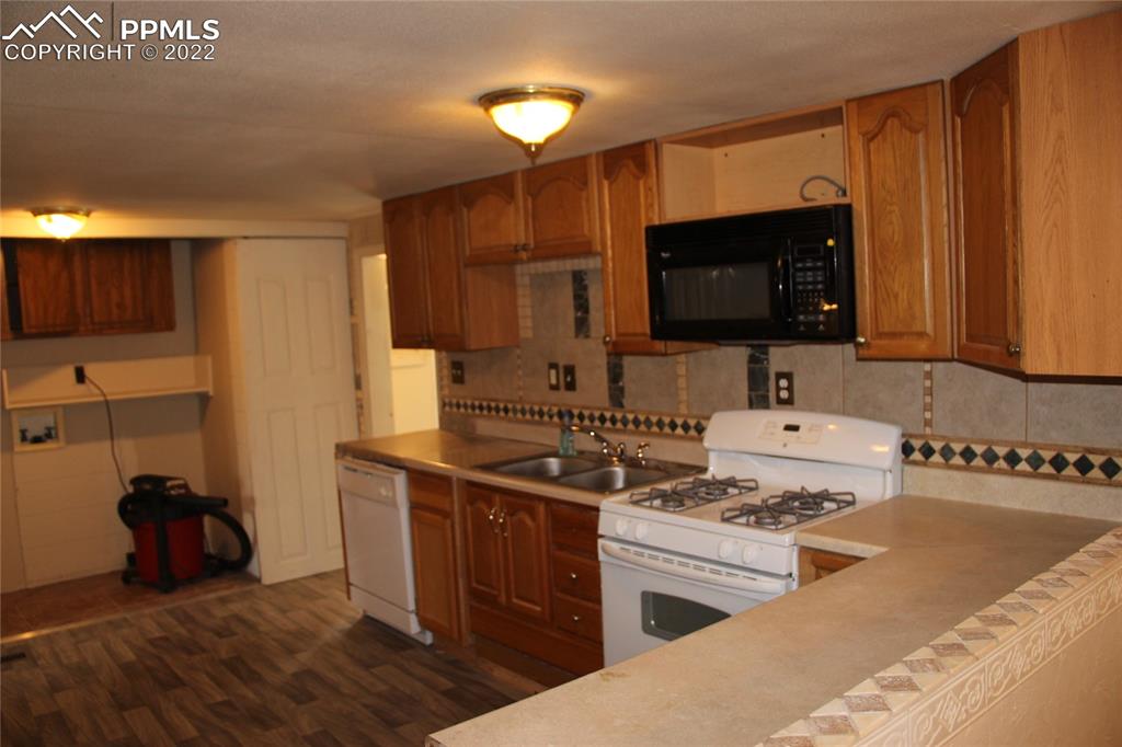 11905 Paint Mine Road Calhan, CO 80808 - Photo 3 of 35 a kitchen with stainless steel appliances a stove a sink and a microwave