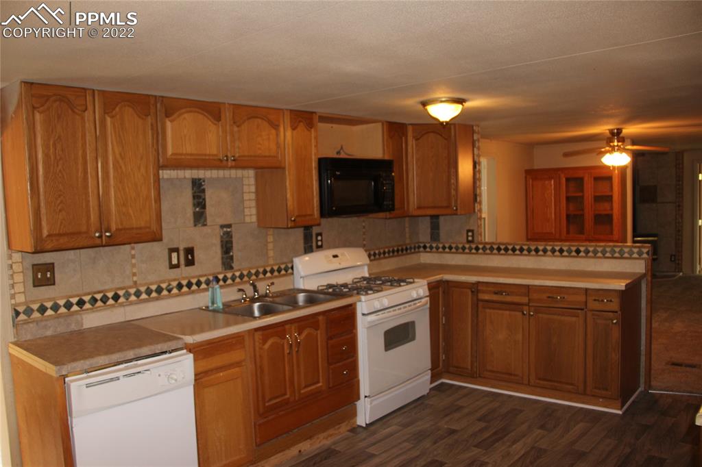 11905 Paint Mine Road Calhan, CO 80808 - Photo 4 of 35 a kitchen that has a sink and a stove in it