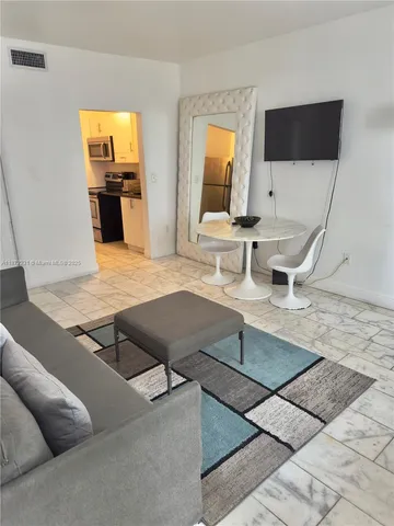 a living room with chairs and a flat screen tv
