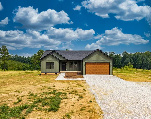 a front view of a house with yard and ocean view