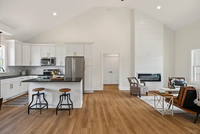 a kitchen with stainless steel appliances a dining table chairs stove microwave and cabinets