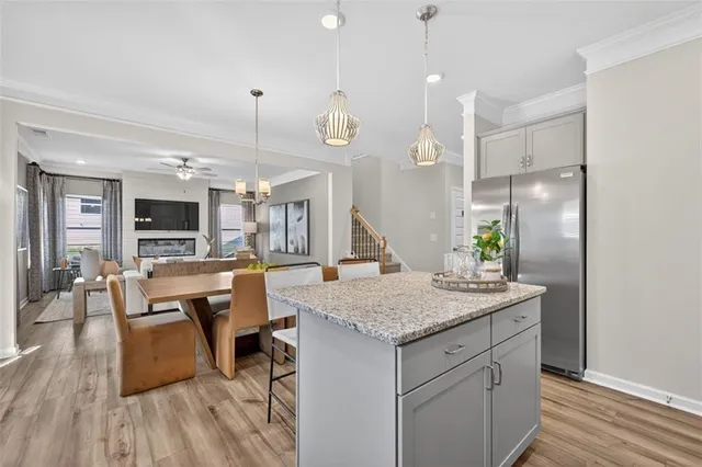 a open kitchen with a table chairs and wooden floor