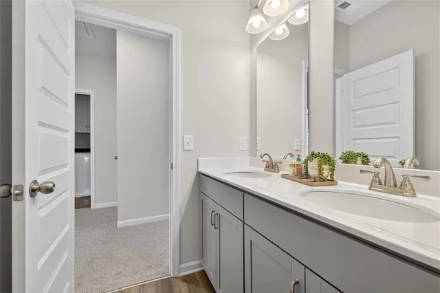 a bathroom with a sink double vanity granite tub shower and a mirror