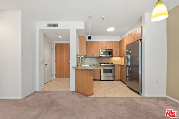 a kitchen with stainless steel appliances granite countertop a refrigerator and a sink
