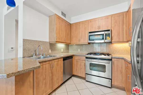 a kitchen with stainless steel appliances granite countertop a stove microwave and sink