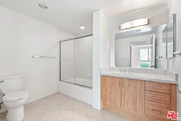 a bathroom with a granite countertop sink a toilet and a mirror