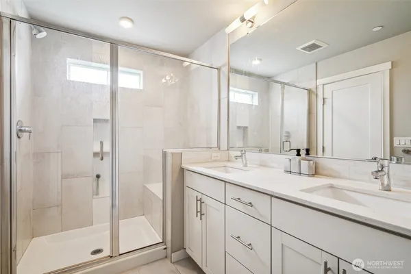 a bathroom with a shower sink and mirror