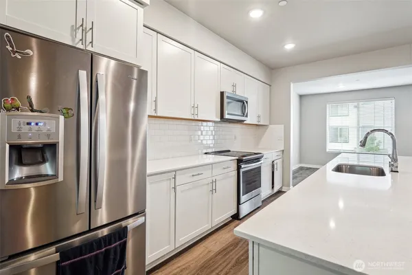 a kitchen with stainless steel appliances a refrigerator sink and microwave