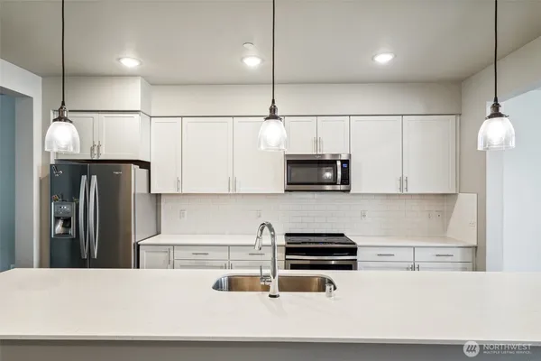 a kitchen with stainless steel appliances a refrigerator a stove a microwave and wooden cabinets