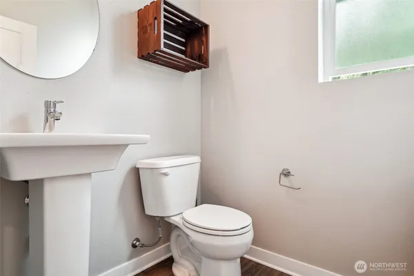 a bathroom with a toilet a sink and mirror