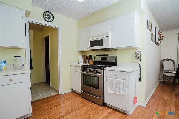 a kitchen with stainless steel appliances granite countertop a refrigerator and cabinets