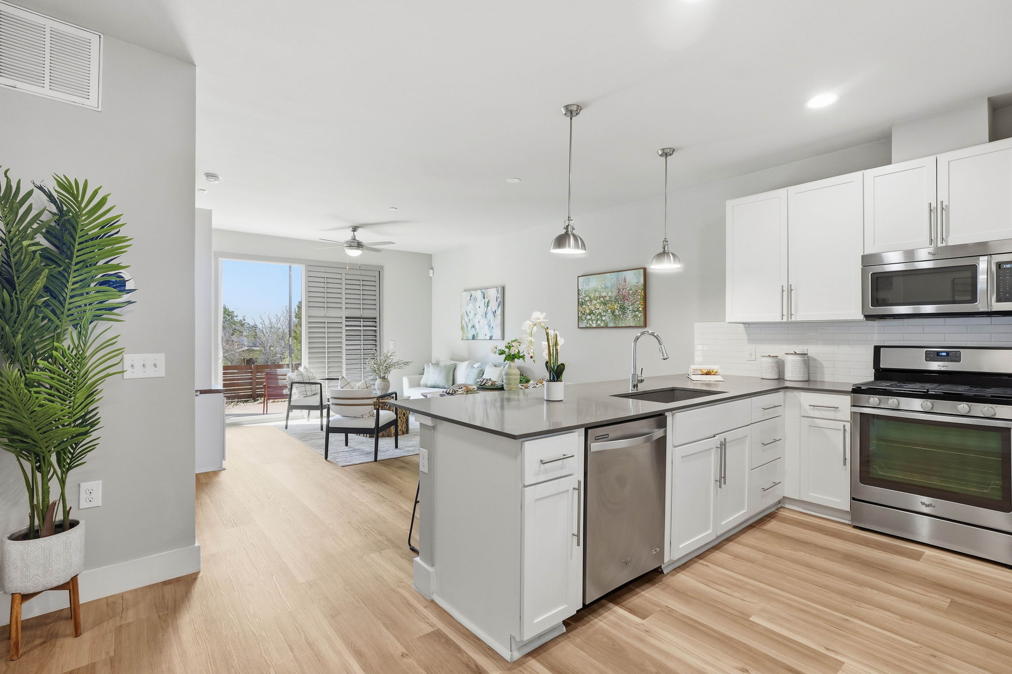 2805 Dulce Lane, Unit 1002 Austin, TX 78704 - Photo 11 of 24 Kitchen with stainless steel appliances, white cabinets, decorative backsplash, a peninsula, and pendant lighting