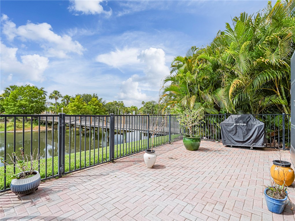 4570 Bridgepointe Way, Unit 148 Vero Beach, FL 32967 - Photo 28 of 32 a view of a deck with a table and chairs next to a yard