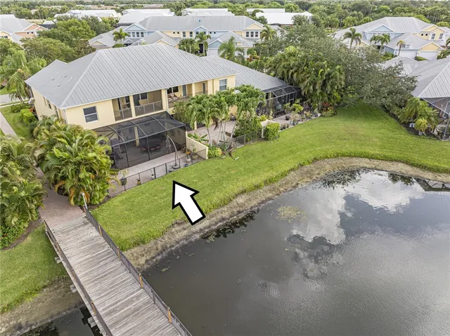 an aerial view of a house with swimming pool and outdoor seating