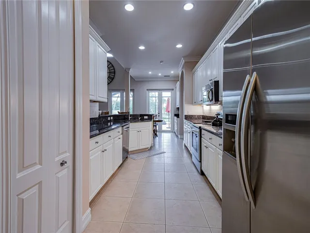 a large kitchen with a large counter top stainless steel appliances and cabinets