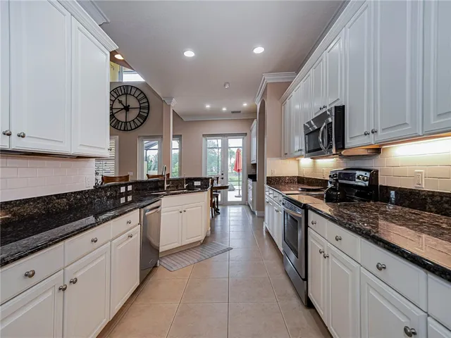a large kitchen with stainless steel appliances granite countertop a lot of counter space and a sink