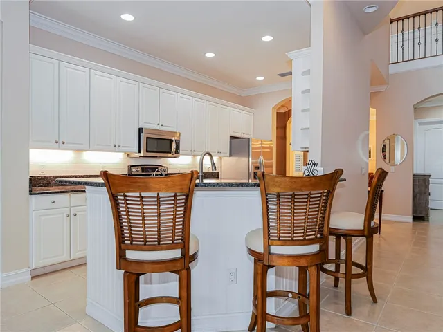 a kitchen with stainless steel appliances granite countertop a kitchen island a table and chairs