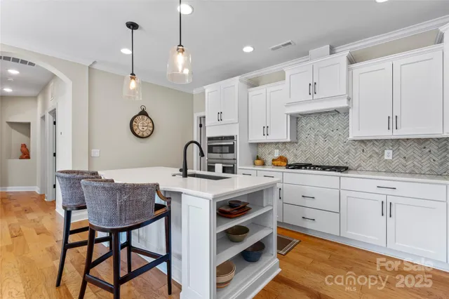 a kitchen with a stove a sink cabinets and stainless steel appliances