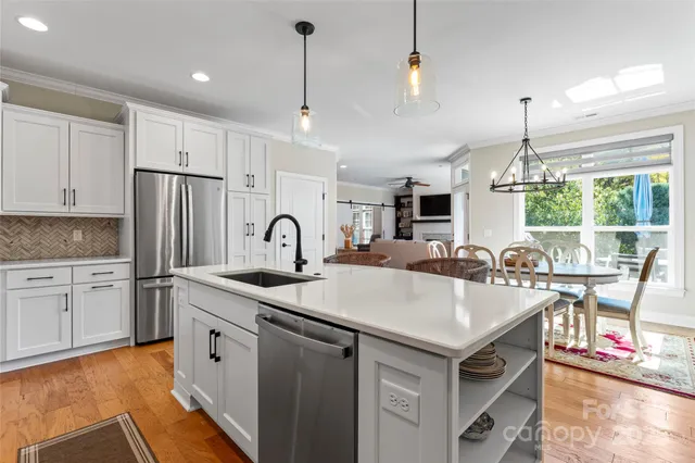 a kitchen with stainless steel appliances granite countertop a sink stove and refrigerator