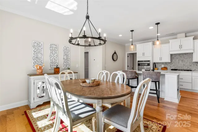 a view of a dining room with furniture a chandelier and wooden floor
