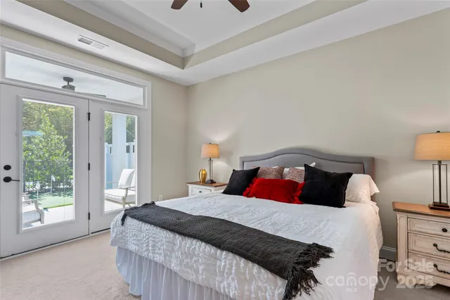 a bedroom with a large bed and a lamp on dresser