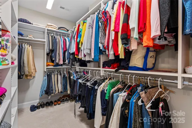 a view of walk in closet with clothes