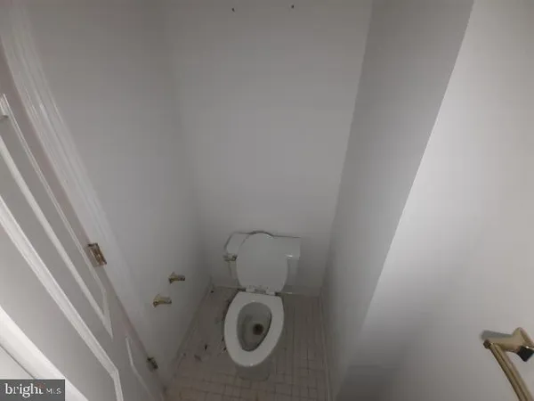 a bathroom with a granite countertop toilet and a sink