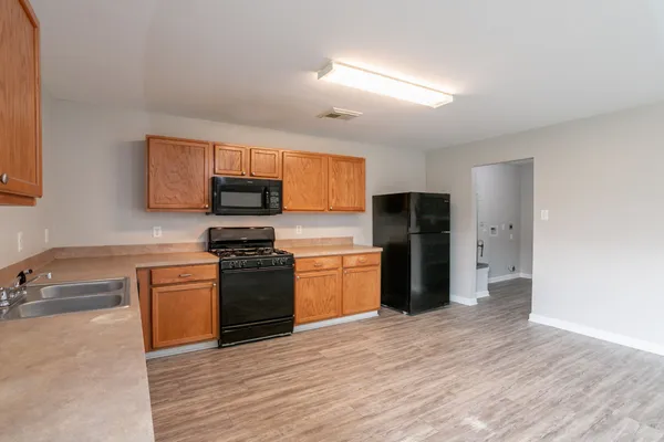 a kitchen with granite countertop a refrigerator and a stove top oven