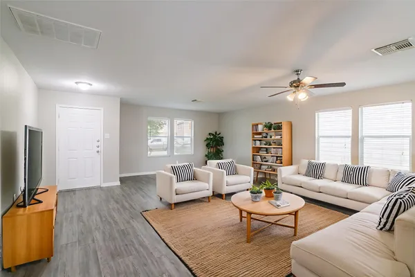 a living room with furniture flat screen tv and window