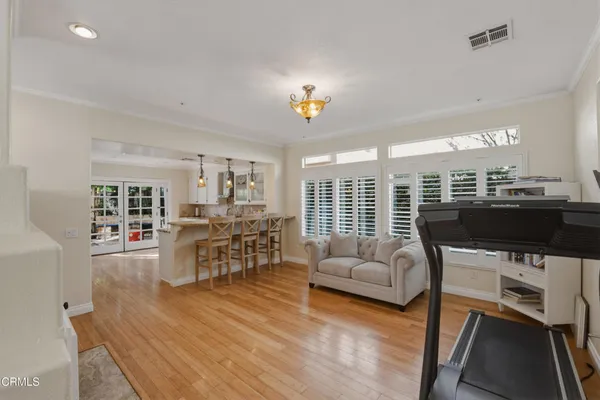 a living room with furniture a dining table and chairs with wooden floor