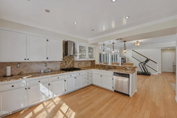 a kitchen with granite countertop a stove and white cabinets