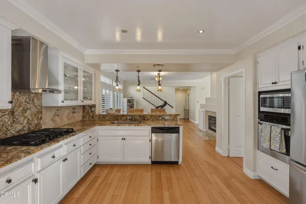 a large kitchen with stainless steel appliances granite countertop a lot of counter space and wooden floors