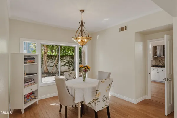a dining room with furniture a chandelier and wooden floor