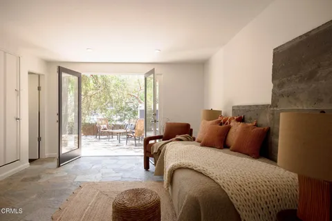 a bedroom with bed and glass door