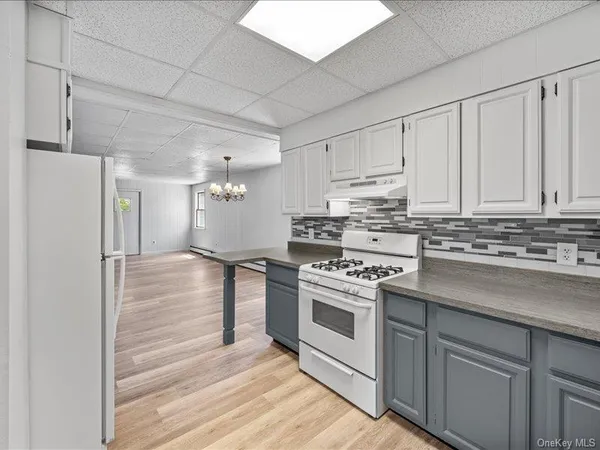 a kitchen with stainless steel appliances white cabinets and a stove top oven