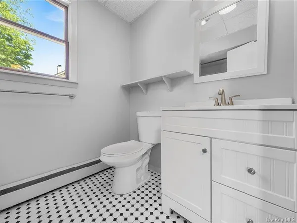 a bathroom with a sink a toilet and a window