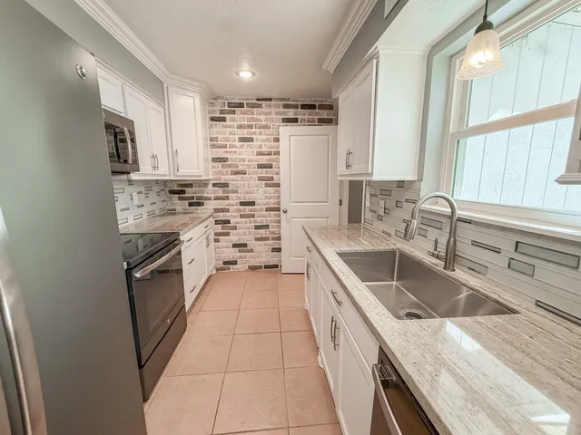 a kitchen with stainless steel appliances granite countertop a sink stove and refrigerator