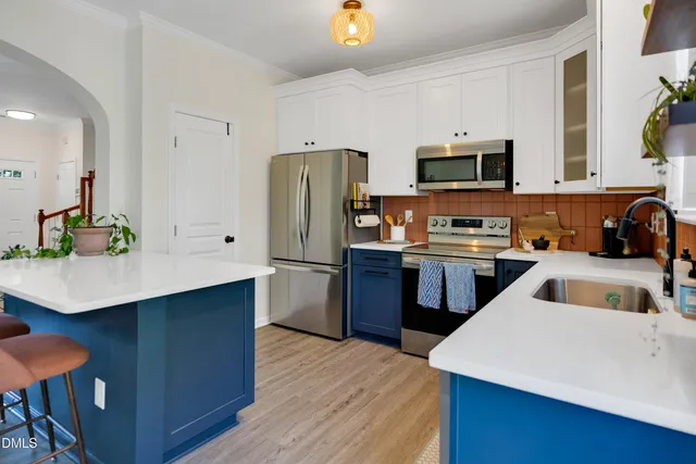 a large kitchen with cabinets wooden floor and stainless steel appliances