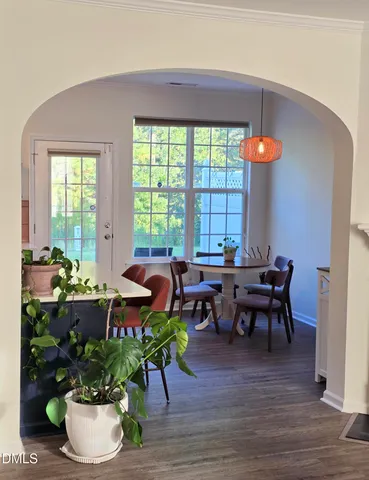 a kitchen with stainless steel appliances a dining table chairs refrigerator and sink