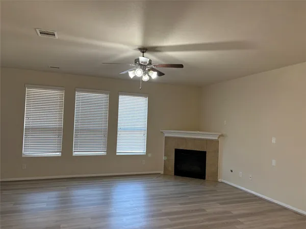wooden floor fireplace and windows in an empty room