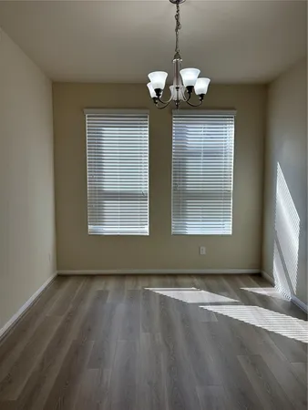 a view of livingroom with window chandelier and wooden floor