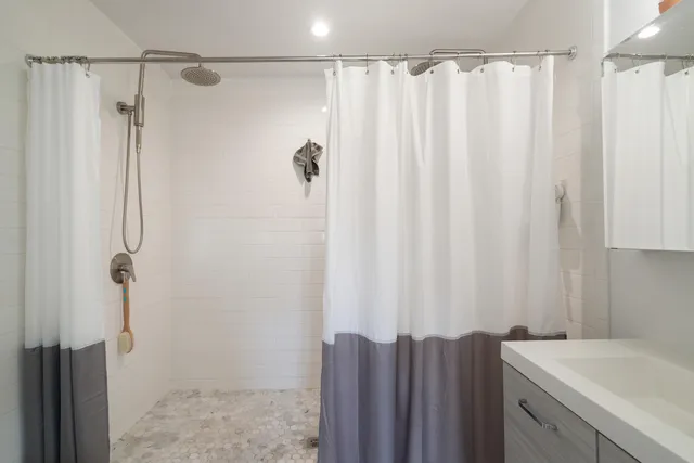 a bathroom with a sink a mirror and shower