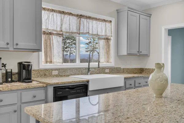 a kitchen with granite countertop a sink and a stove