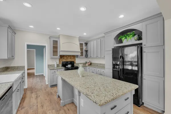 a kitchen with granite countertop kitchen island a counter space a sink stainless steel appliances and cabinets