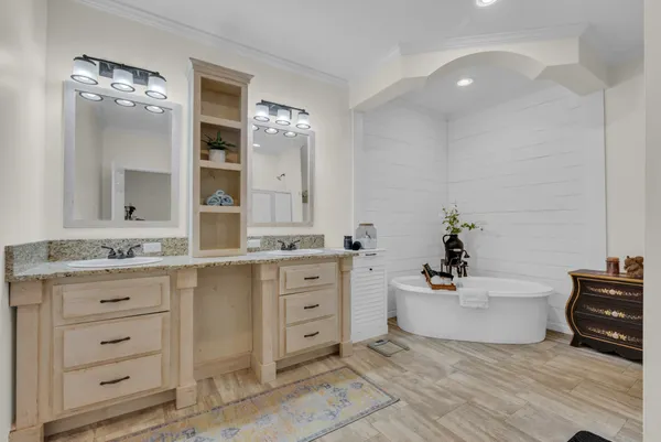 a spacious bathroom with a granite countertop sink mirror and bathtub
