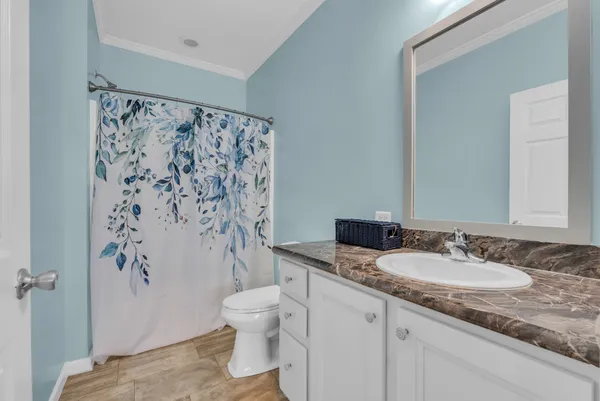 a bathroom with a granite countertop sink toilet and shower