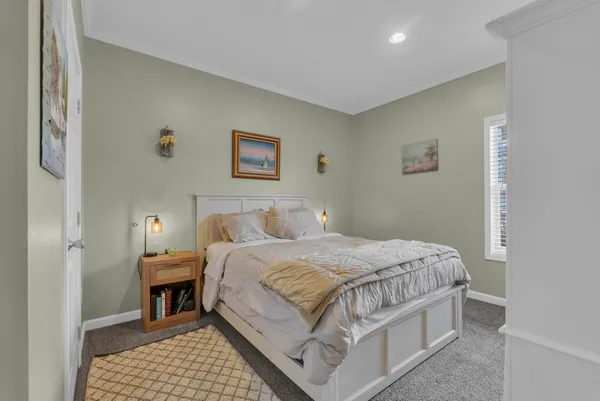 a bedroom with a bed and a painting on the wall