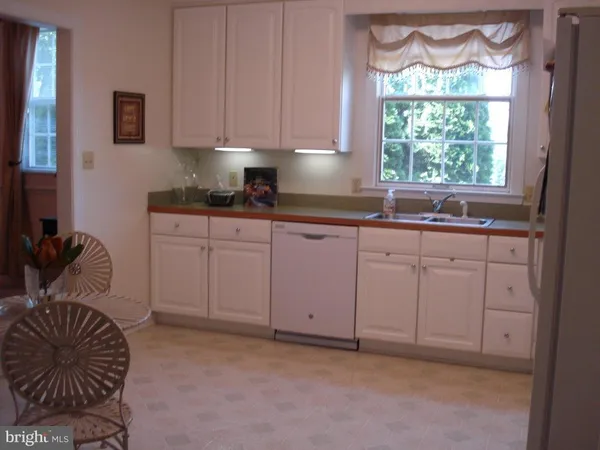 a kitchen with white cabinets and window